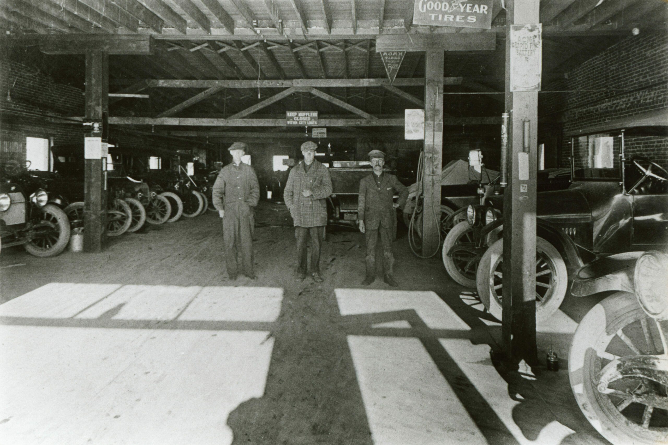 Possibly inside the Colorado Auto Company - Signs read “Good Year Tires,” “Ajax Tires,” “Acme Rapid Fire Battery,” “KEEP MUFFLERS CLOSED WITHIN CITY LIMITS”