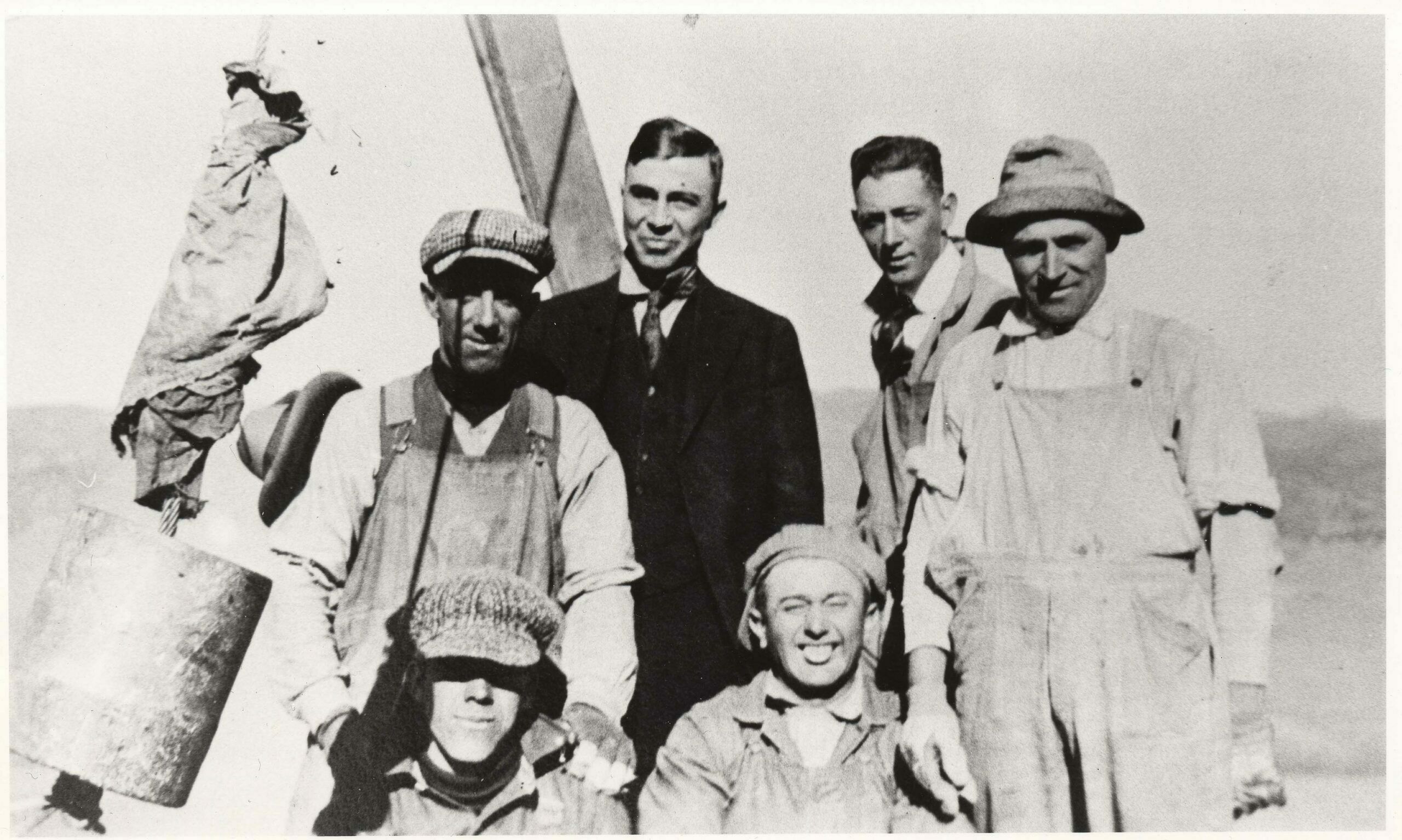 Unidentified workers who built the 365-foot smokestack grin happily as they pose with their boss, assistant superintendent Arthur Thomson, atop the stack November 14, 1917, during a simple topping out ceremony held that day. Thomson placed a silver dollar in the wet mortar of the last few bricks. Town clerk Bertie Roney, the first woman to the top of the stack, was hoisted in the materials bucket. Because she isn’t in any of the photos taken that day and the shadow of a woman’s hat is, Miss Roney was likely the photographer who recorded the event. She exposed four or five negatives that were later given to Arthur Thomson, who passed them to his son, Frank, of Poncha Springs.  (1)