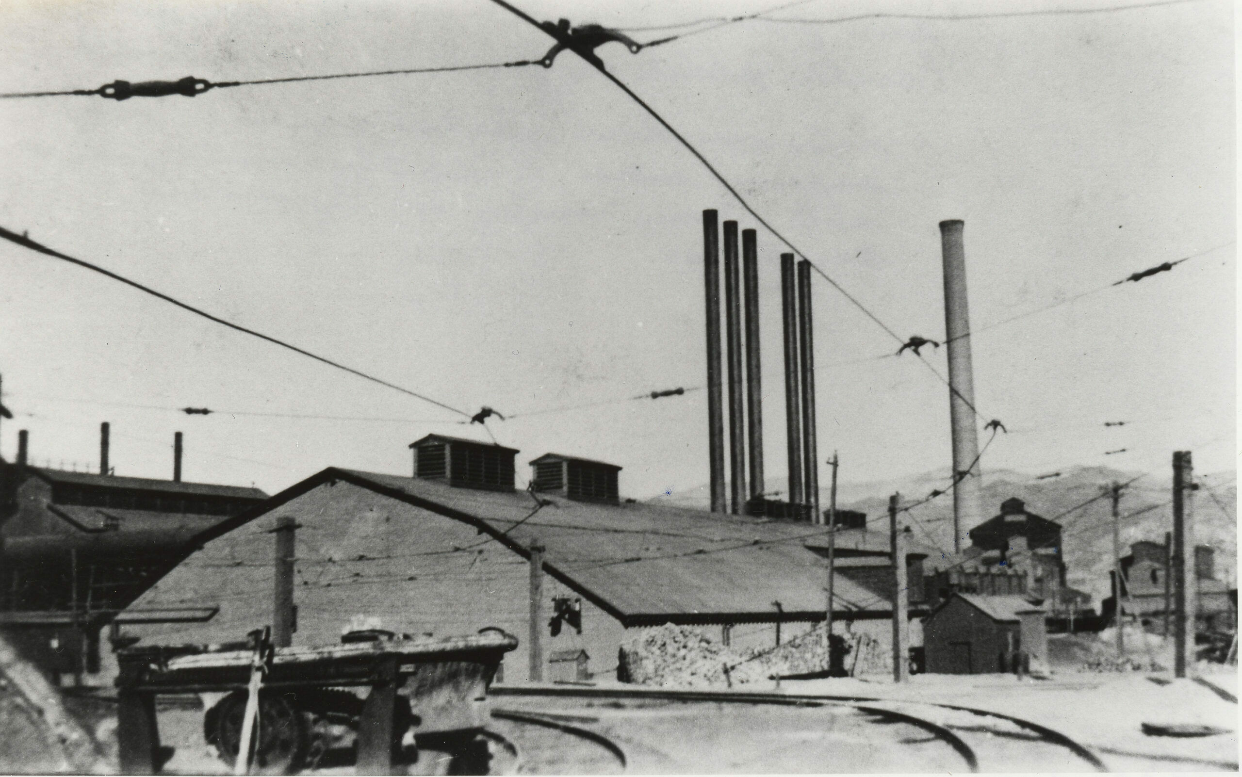 The smelter, on the slag dump looking East at the power house and the smokestack, note the center plant in front of the smokestack. The overhead cables supplied electricity. The slag engines were evidently motorized, not steam mules as in other smelters.